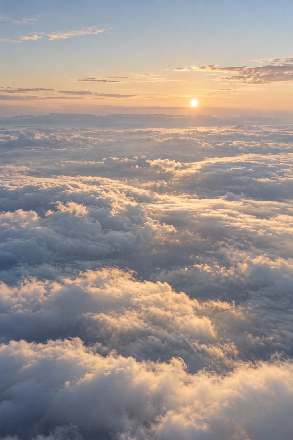 Sunrise light runs across a sea of cloud from the far horizon.